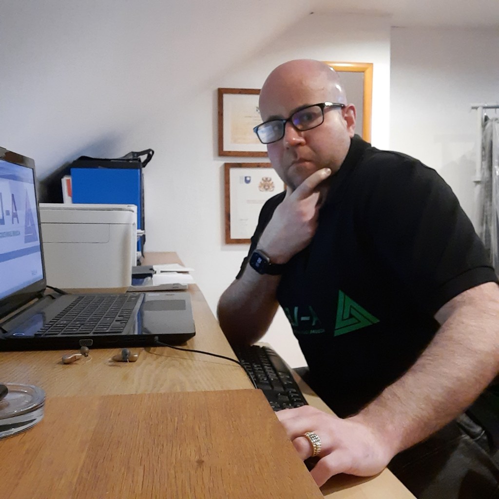 photo of David Howie sitting at his desk facing the camera.  